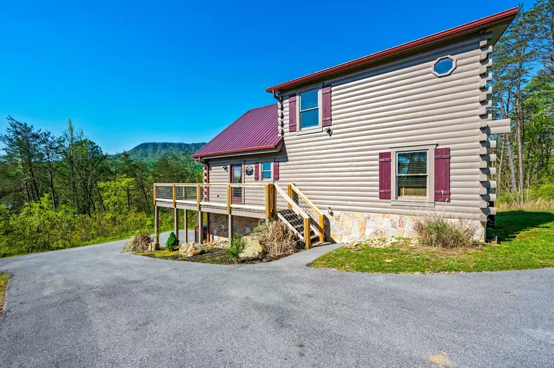 Nothin’ But a Good Time – a spacious 4-bedroom Smoky Mountain cabin rental in Sevierville featuring king bedrooms, twin bunks, hot tub, theater room, fire pit, and cozy mountain views.
