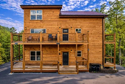 Bright, welcoming exterior with easy parking, two levels of wrap-around decks for enjoying the views, and modern cabin design.