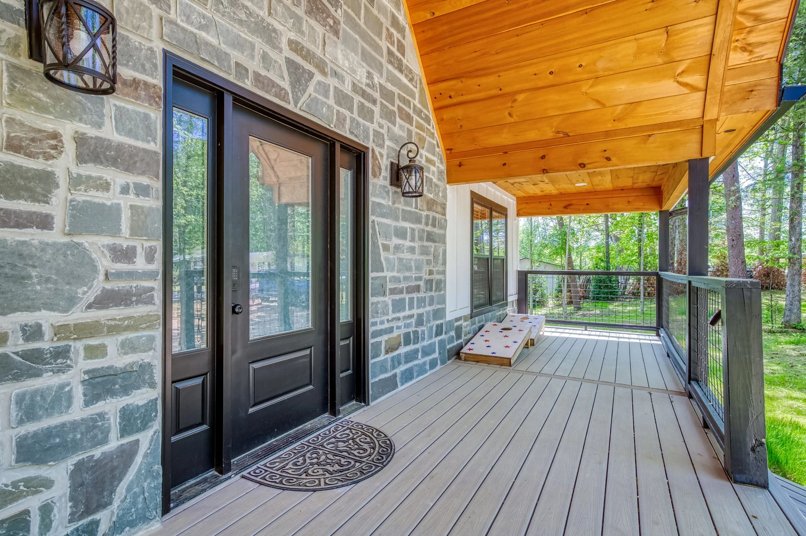 Mountain Lake Home covered entry deck with corn hole