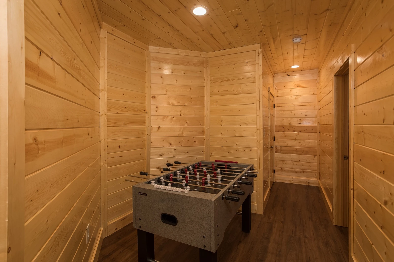 Open game room with foosball, arcade, and pool table overlooking indoor pool