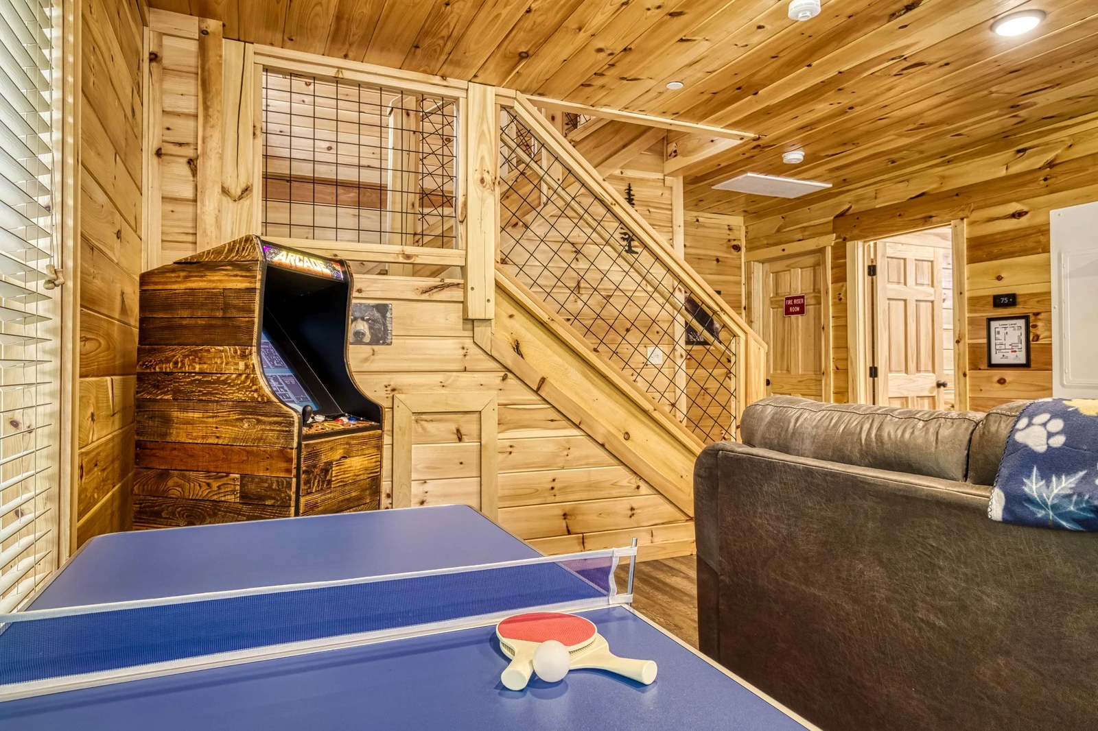 Mountain Memories lower level game room with ping pong table and stand up arcade machine