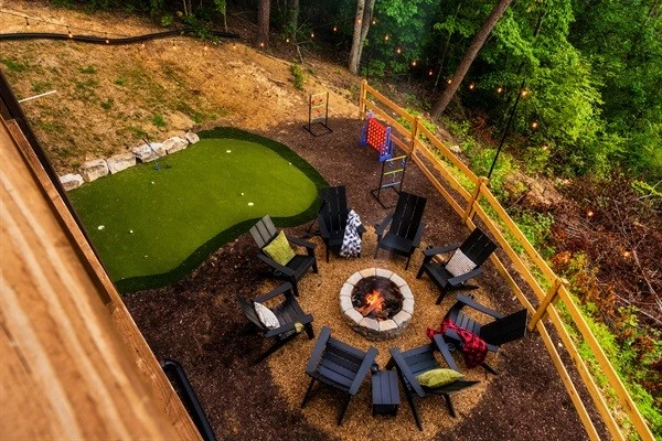 Backyard with fire pit, mini golf, string lights and games