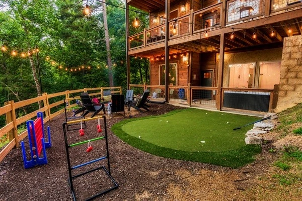 Backyard with fire pit, mini golf, string lights and games
