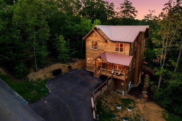 Luxury cabin with multiple decks with string lights, hot tub, and backyard with fire pit and mini golf