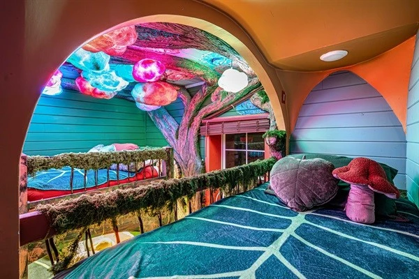 Magical bunk room. The forest canopy ceiling glows and shimmers with magical colors. Magical forest dreamscape: two queens and four XL twin beds. Plus a hobbit door!