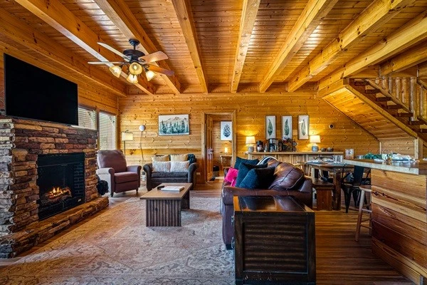 Spacious open-concept living area with fireplace, comfortable seating, and seamless flow into the kitchen and dining space—perfect for large groups and gathering