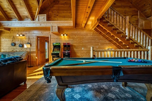 Game area featuring a full-size pool table and arcade machines—perfect for family fun and friendly competition.