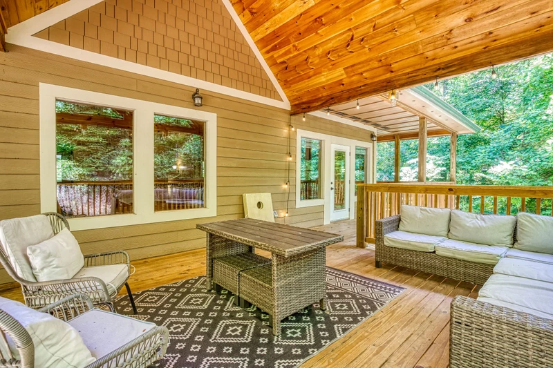 Woodness Gracious upper level covered back deck with cushioned sitting area