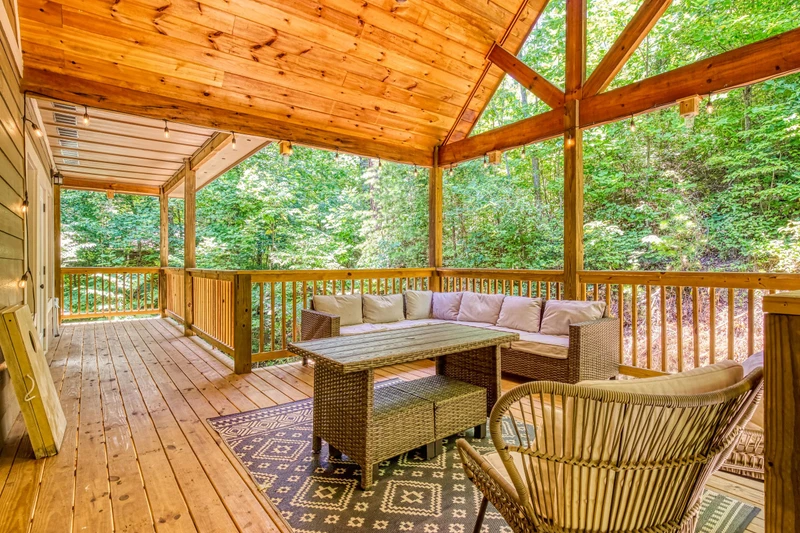 Woodness Gracious cushioned sitting area on upper level covered back deck