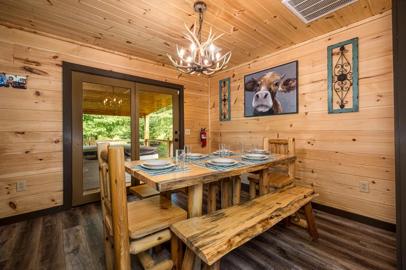 Cabin dining room with log table and bench.