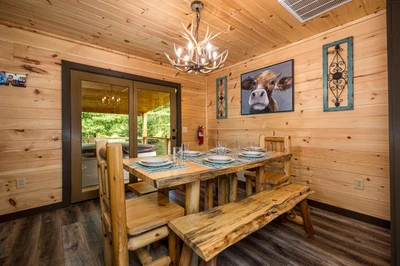 Cabin dining room with log table and bench.