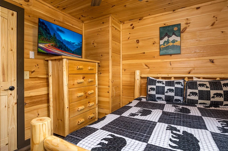 Rental cabin bedroom with tv.