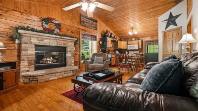 Stacked stone gas log fireplace and plush leather couch.