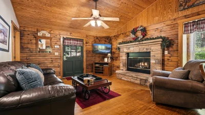 Cabin rental living room with stacked stone fireplace.