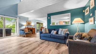 Your relaxing Gatlinburg chalet's living room with large glass doors looking out over a forest setting.