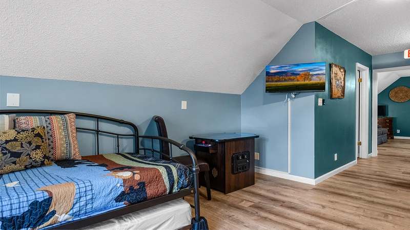The game room offers more sleeping space with a flat screen TV. 