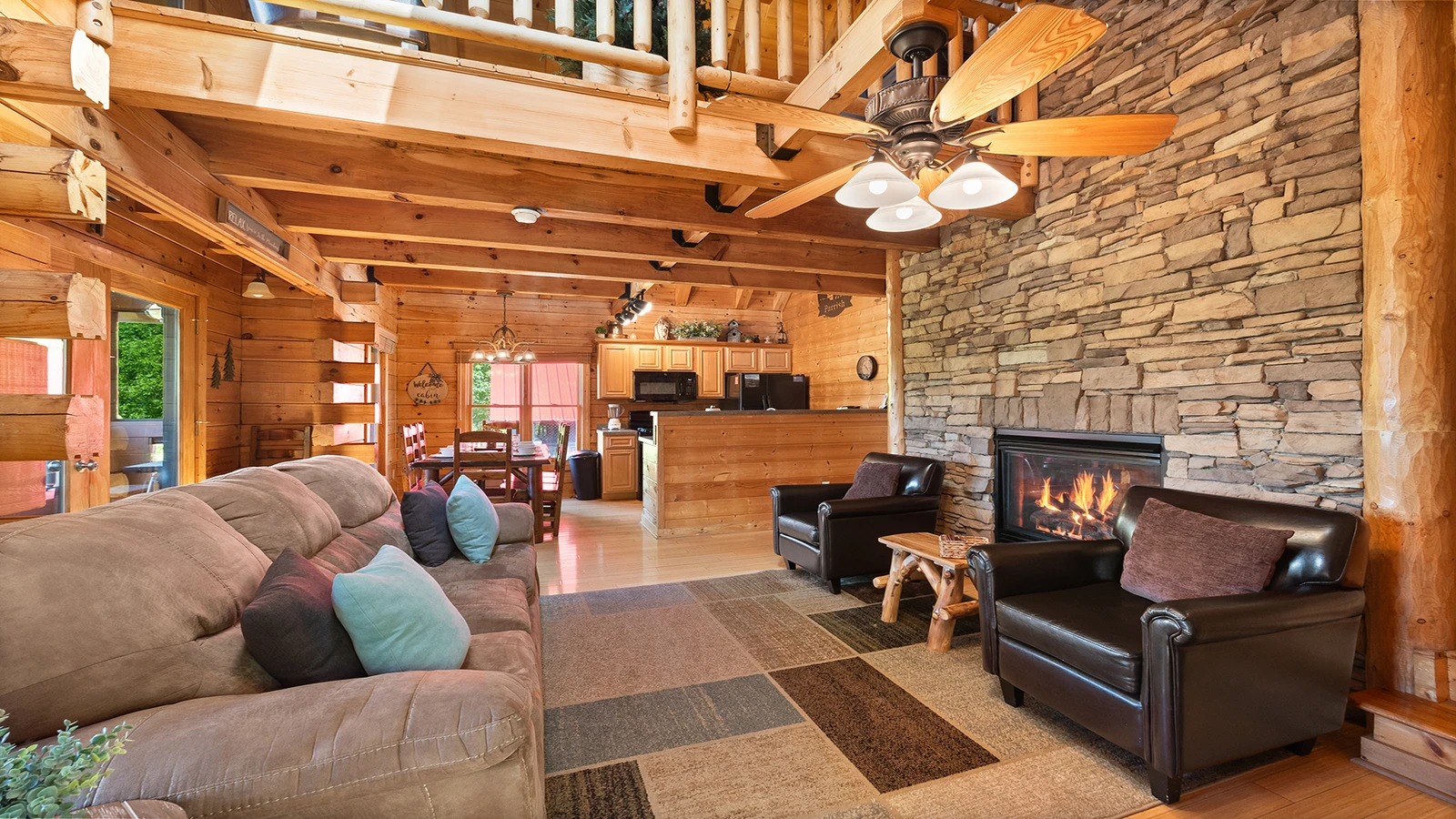 Cabin living room with stacked stone gas log fireplace.