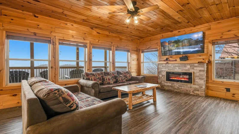 Open spacious cabin living room with gas log fireplace.