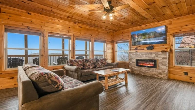 Open spacious cabin living room with gas log fireplace.