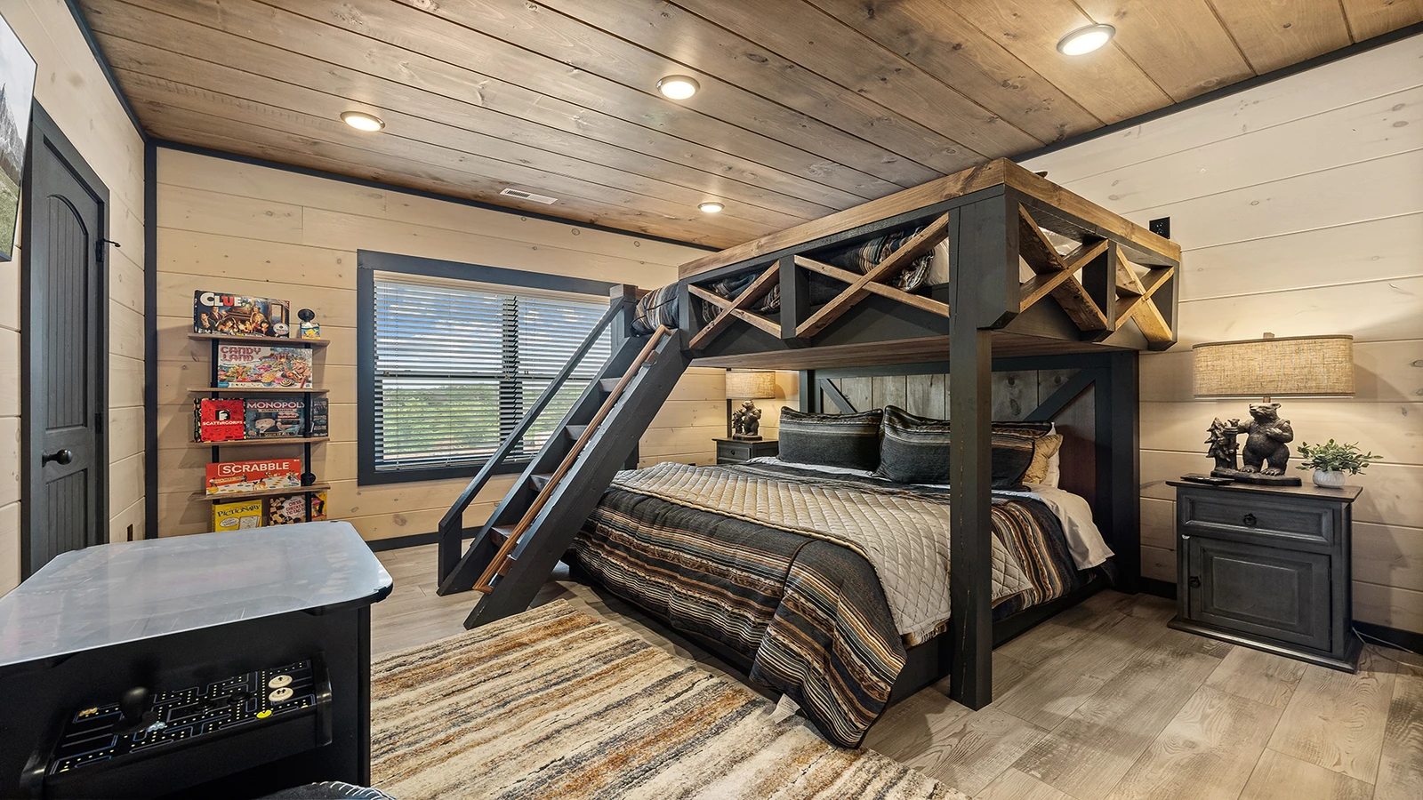 Queen bed on top and king bed below with table-top arcade.