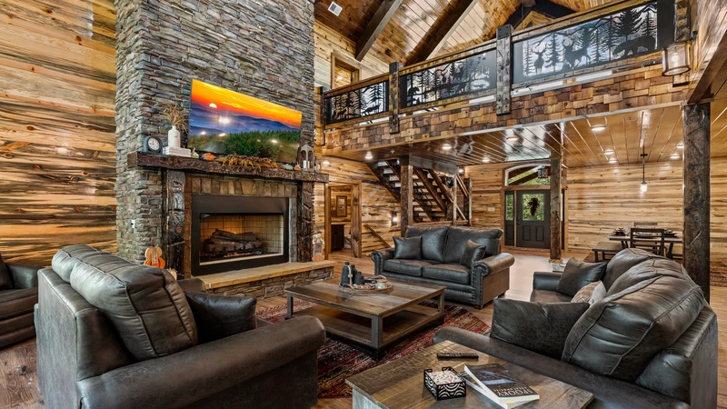 The spacious living room of Waterfall Wanderland with its large stacked stone fireplace.