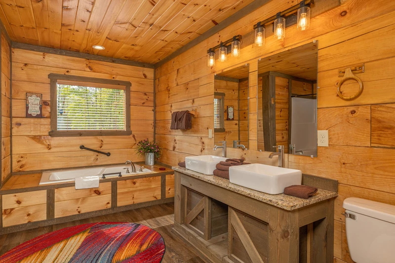 Cabin's master bedroom bath with Jacuzzi tub and dual farm sinks.
