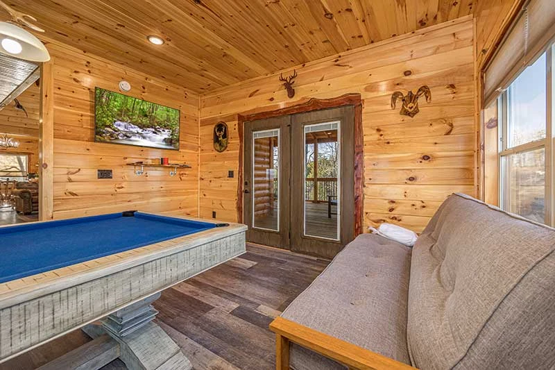 Game room with flat screen tv and futon seating.