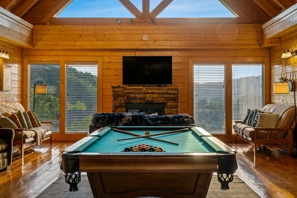 Game room with a full-size pool table, large TV, comfortable seating, and mountain views