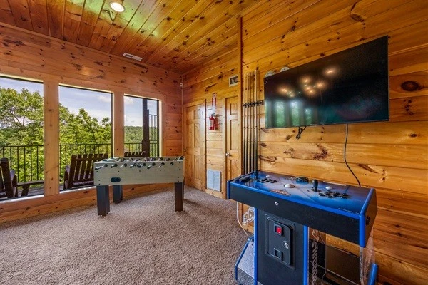 Game room with large windows offering a scenic mountain views and access to a balcony with rocking chairs