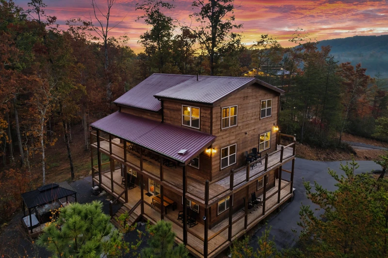 Luxury Smoky Mountain cabin nestled in the Blue Ridge Mountains — stunning aerial view showcasing the full property, wraparound decks, and breathtaking mountain surroundings.
