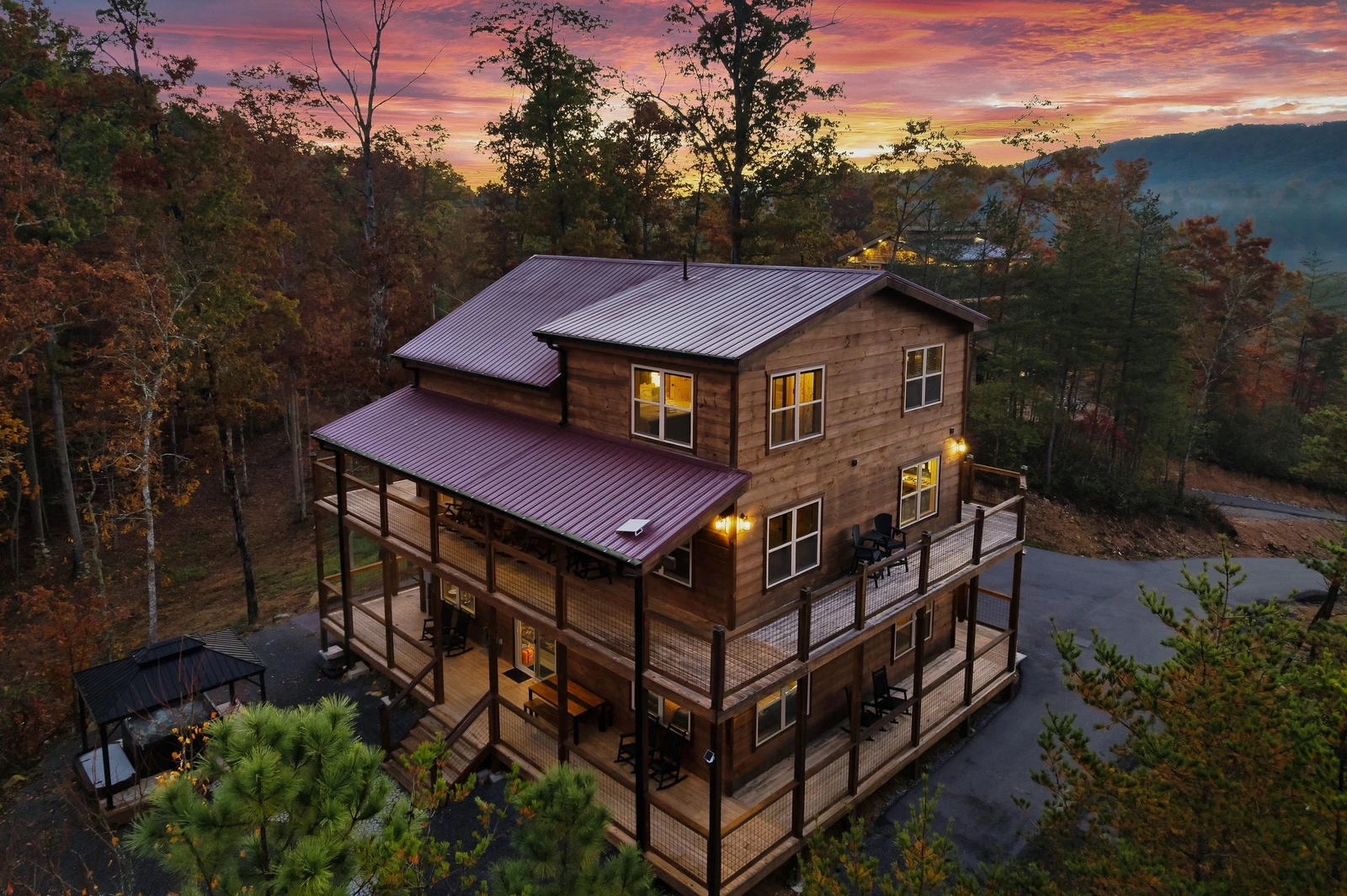 Luxury Smoky Mountain cabin nestled in the Blue Ridge Mountains — stunning aerial view showcasing the full property, wraparound decks, and breathtaking mountain surroundings.