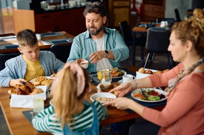 family with kids sharing meal at restaurant