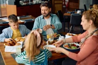 family with kids sharing meal at restaurant