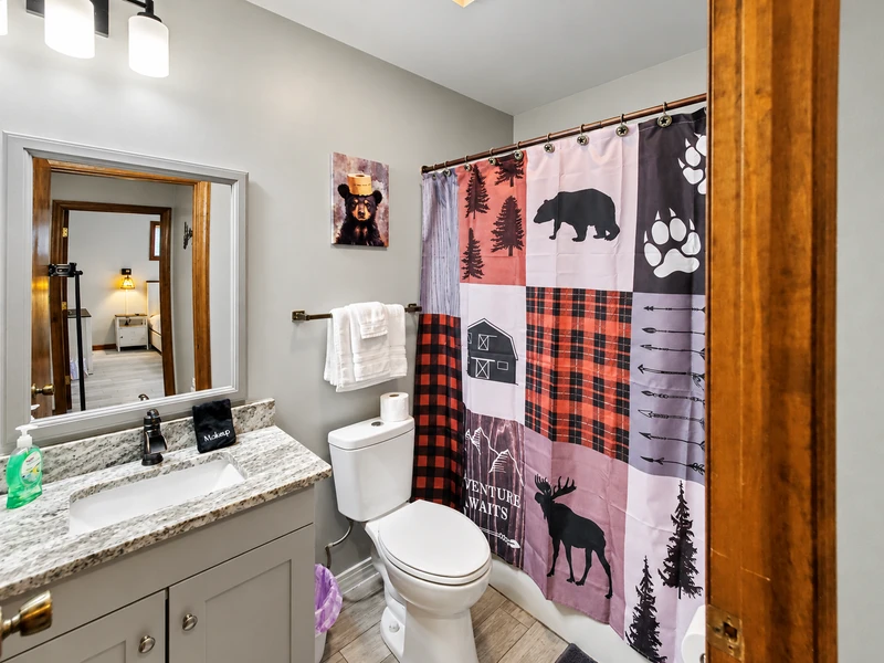 Full hall bathroom with granite vanity top, toilet, and bathtub
