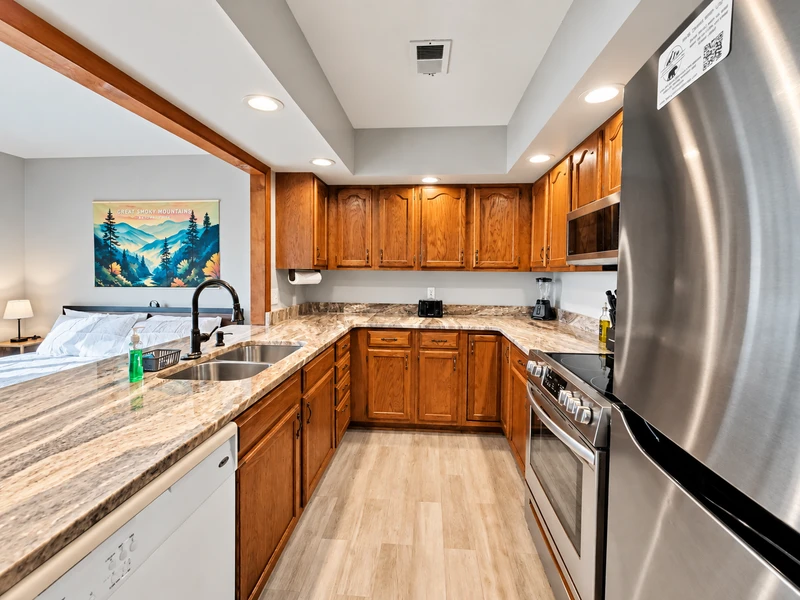 Full featured kitchen with granite countertops, appliances, and full range of cooking utensils