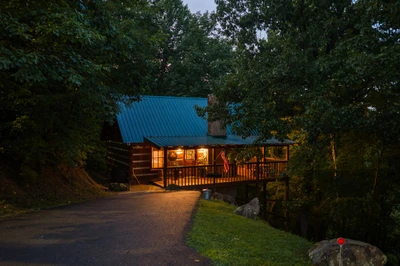 Nestled Oaks cabin glowing at night in the woods