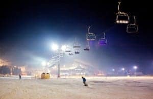 Ski resort at night with man snowboarding