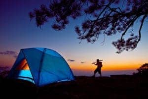 Person camping in nature at sunset