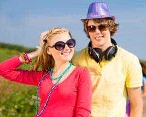 Teenager boy and girl wearing bright colored clothes having fun