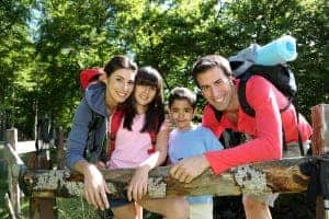 Family hiking and resting on the fence