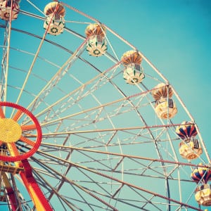 Vintage style photo of ferris wheel in blue sky