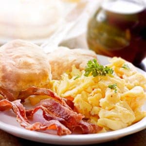 Scrambled eggs, bacon, and biscuits for breakfast