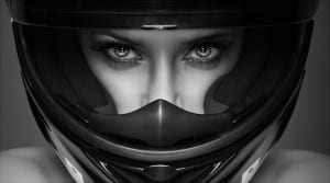 Black and white photo of woman's face wearing helmet for car race