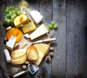 Various types of cheese on wooden background