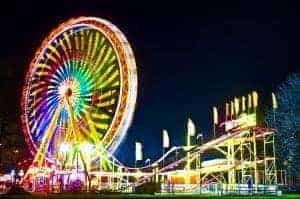 Amusement park with ferris wheel and roller coaster at night