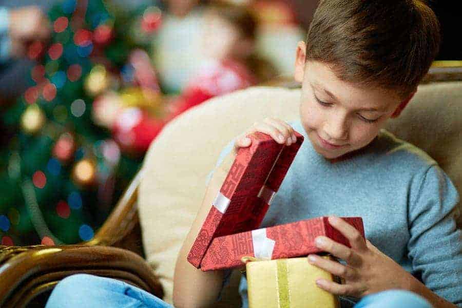 Boy opening up a small present on Christmas morning