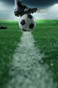 Close up of foot on top of soccer ball on the line
