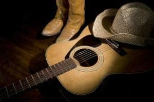 Country music setting with cowboy hat, cowboy boots, and guitar
