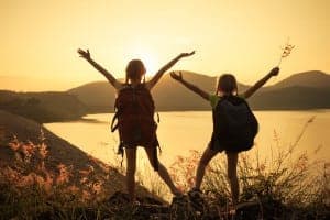 young girls enjoying hike with view of lake