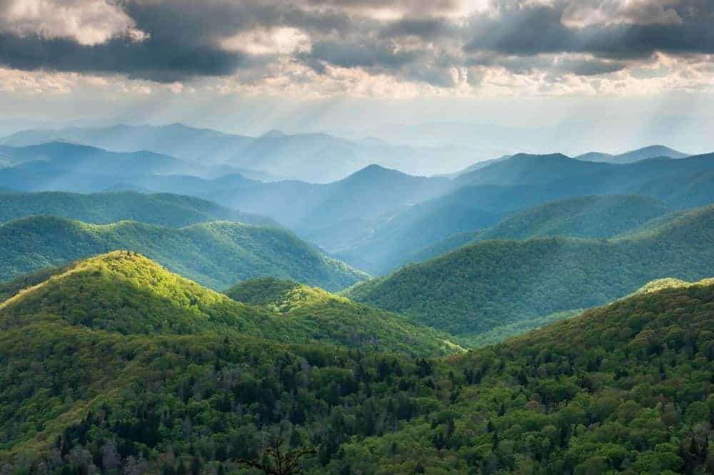 Sun shining down on a view of the beautiful, green Smoky Mountains